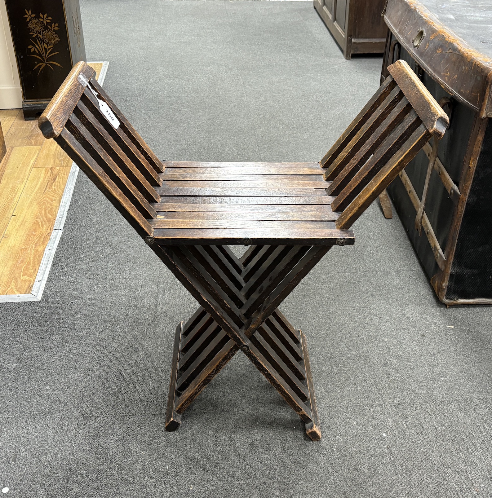 An early 20th century Liberty style oak folding X framed stool, width 61cm, depth 31cm, height 67cm